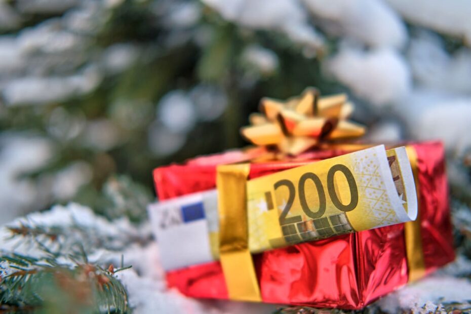Geldgeschenk vor Weihnachtsbaum