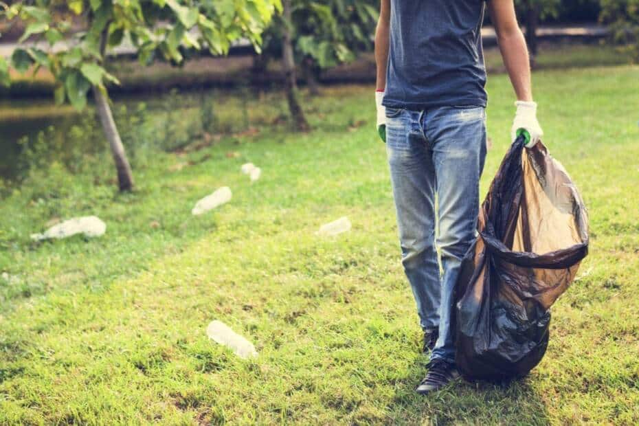 Mann räumt Müll im Park auf