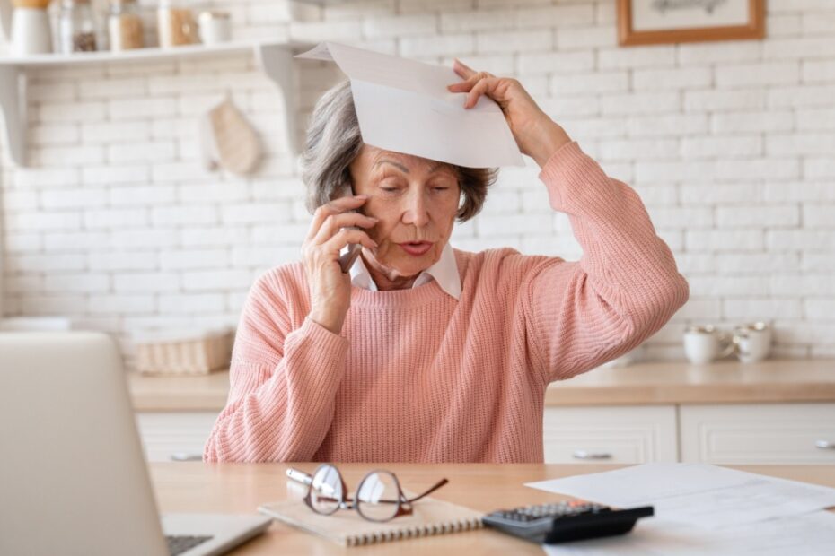 Besorgte Rentnerin am Telefon hält behördliches Schreiben wegen Rente oder Steuern.
