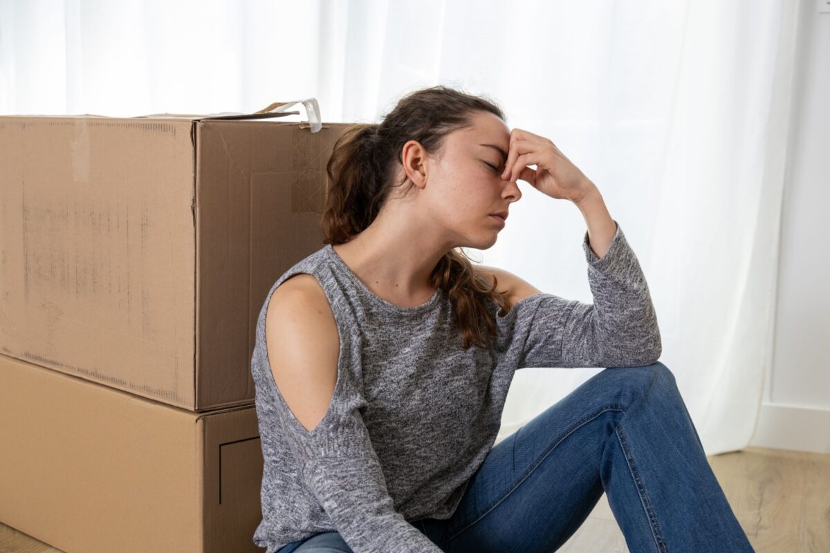 Frustrierte Frau vor gepackten Umzugskartons