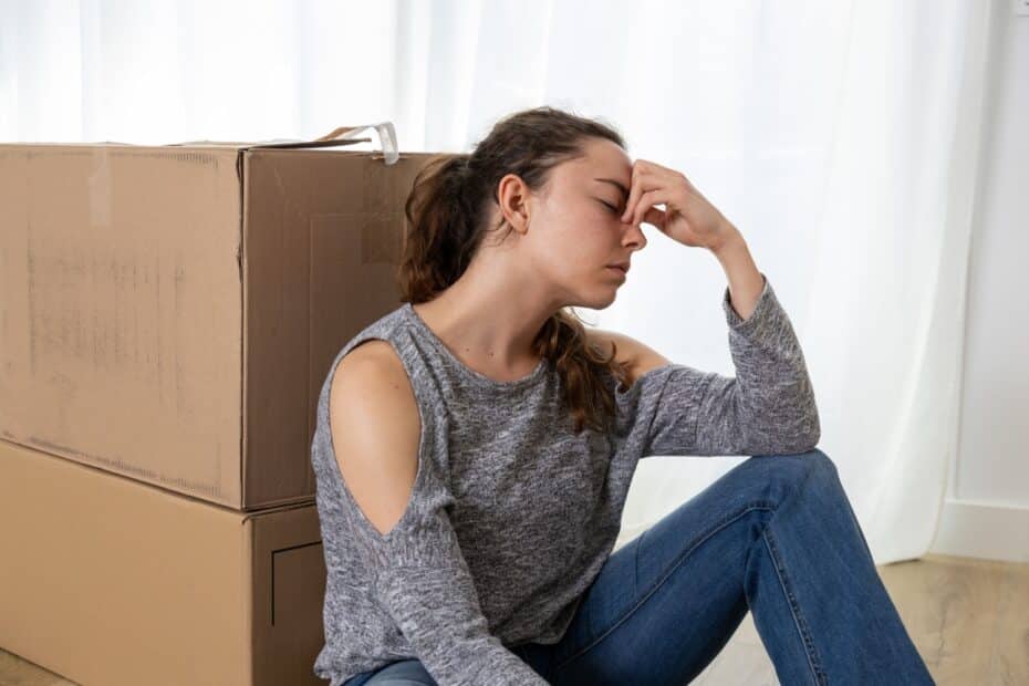 Frustrierte Frau vor gepackten Umzugskartons